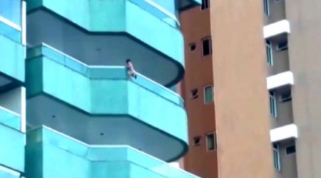 Toddler clambered out over fifth floor balcony - VIDEO