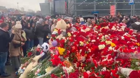 Жители Москвы несут цветы к стихийному мемориалу у «Крокус Сити Холла»