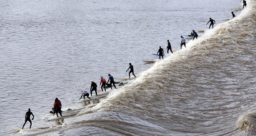 Surfers brave the cold for a group ride on a 20 mile wave - PHOTO Surfers brave the cold for a group ride on a 20 mile wave - PHOTO